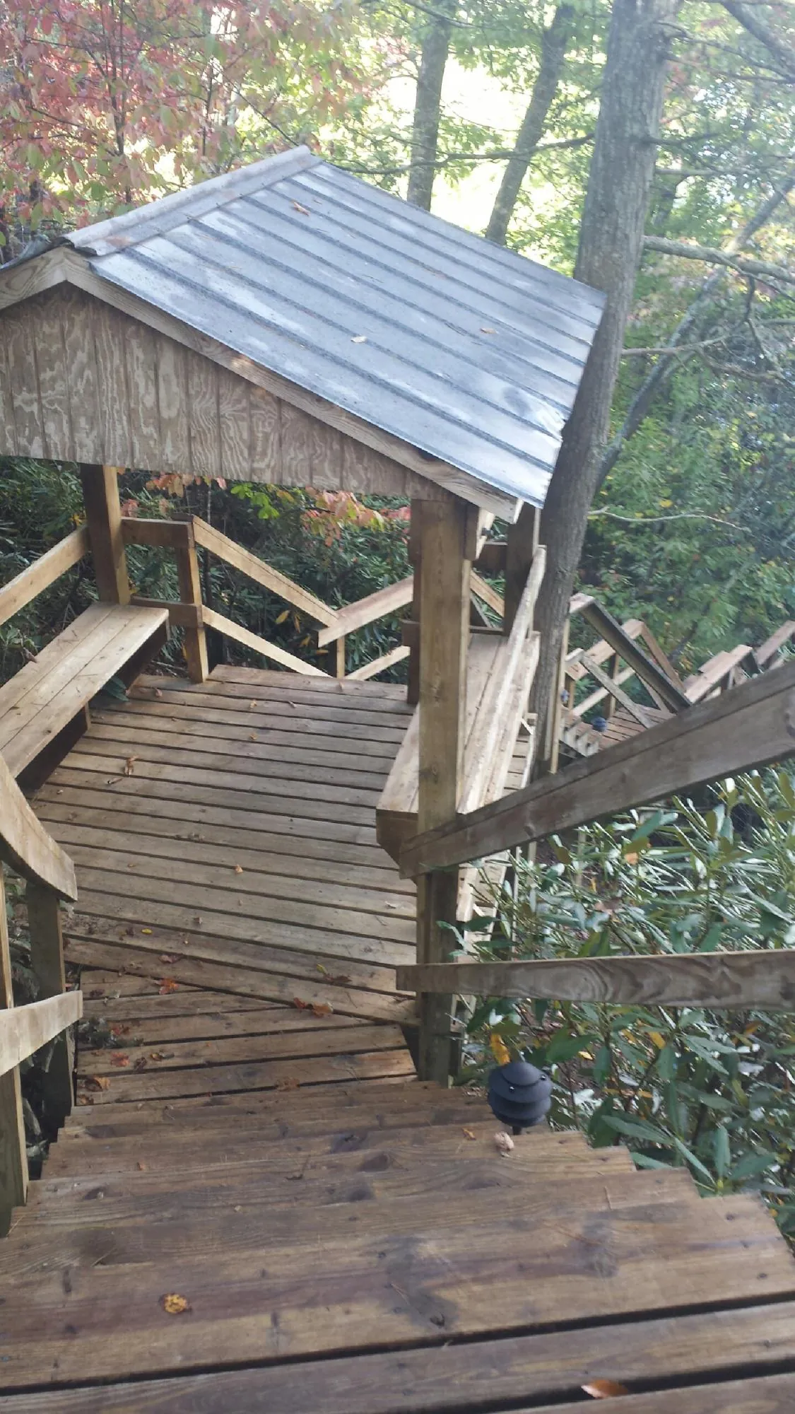 Metal roofed shelter over wooden steps on a wooded walkway — Skylight Repair & Installation work by our crew in Cheyenne